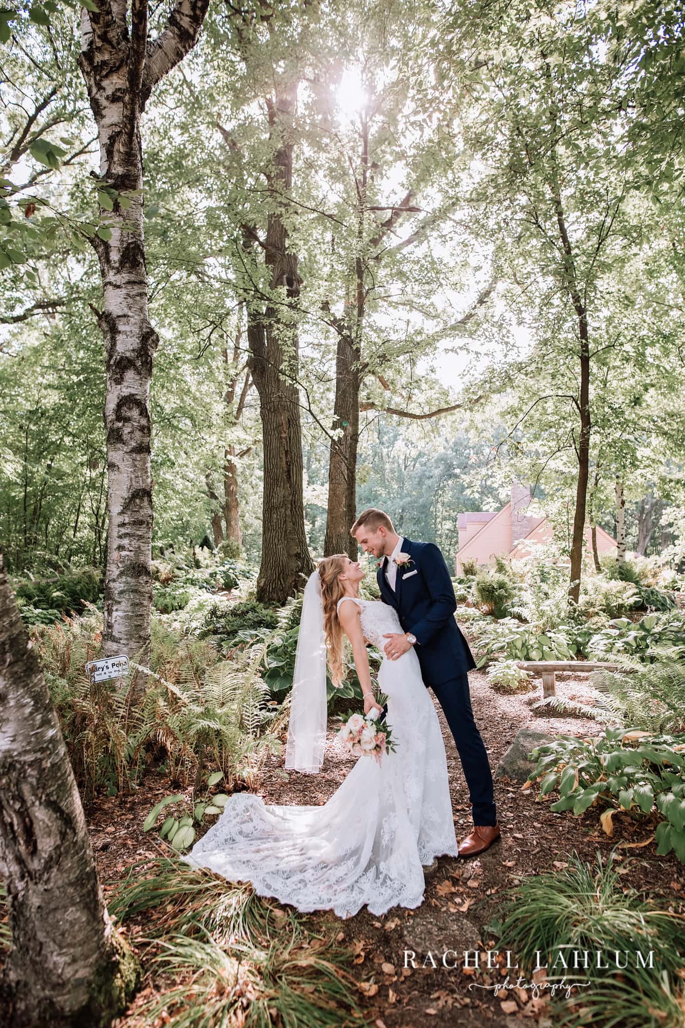 A bride and groom pose in the woods at Panola Valley Gardens for their wedding photography.