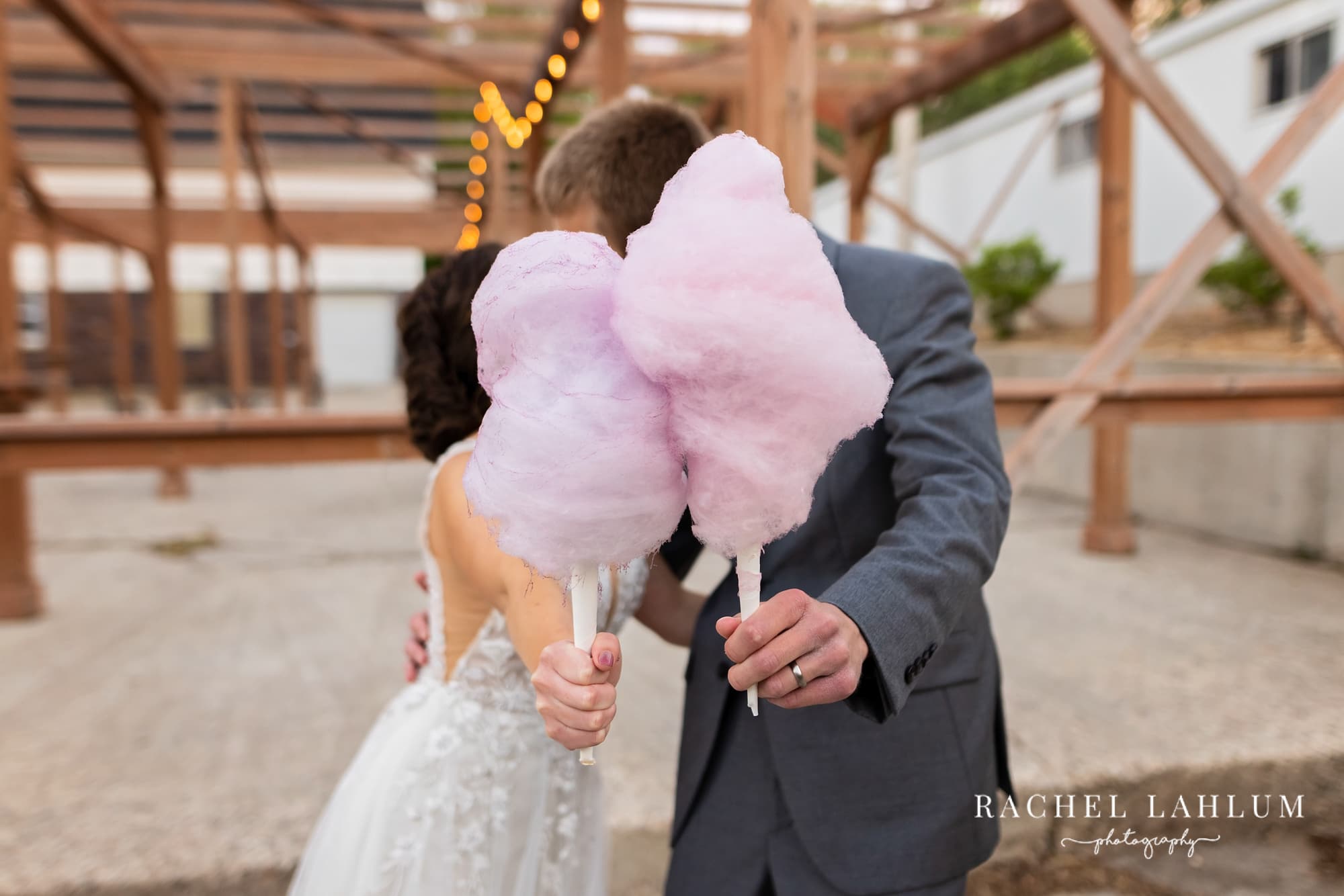 Bride and groom kiss behind cotton candy at The Cottage Farmhouse. 