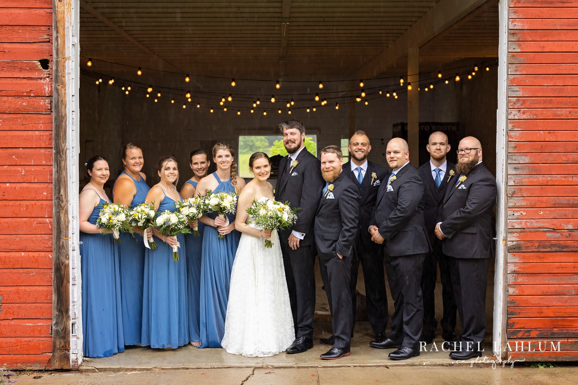 Bridal party fill the entrance of the Cedar Creek Barn Wedding Venue in Winona, Minnesota. 
