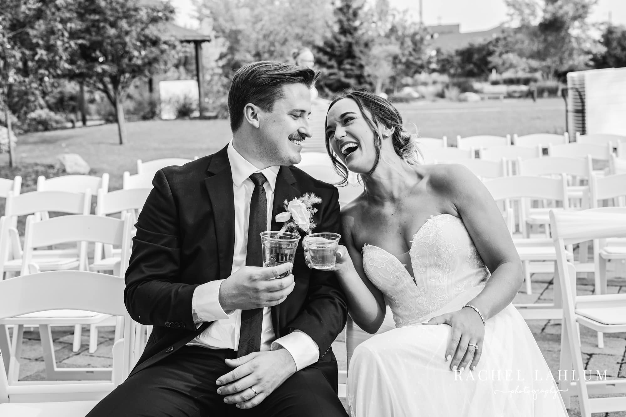 Bride and groom laugh while toasting for a wedding photo at their wedding reception at the Boathouse in Alexandria, Minnesota.