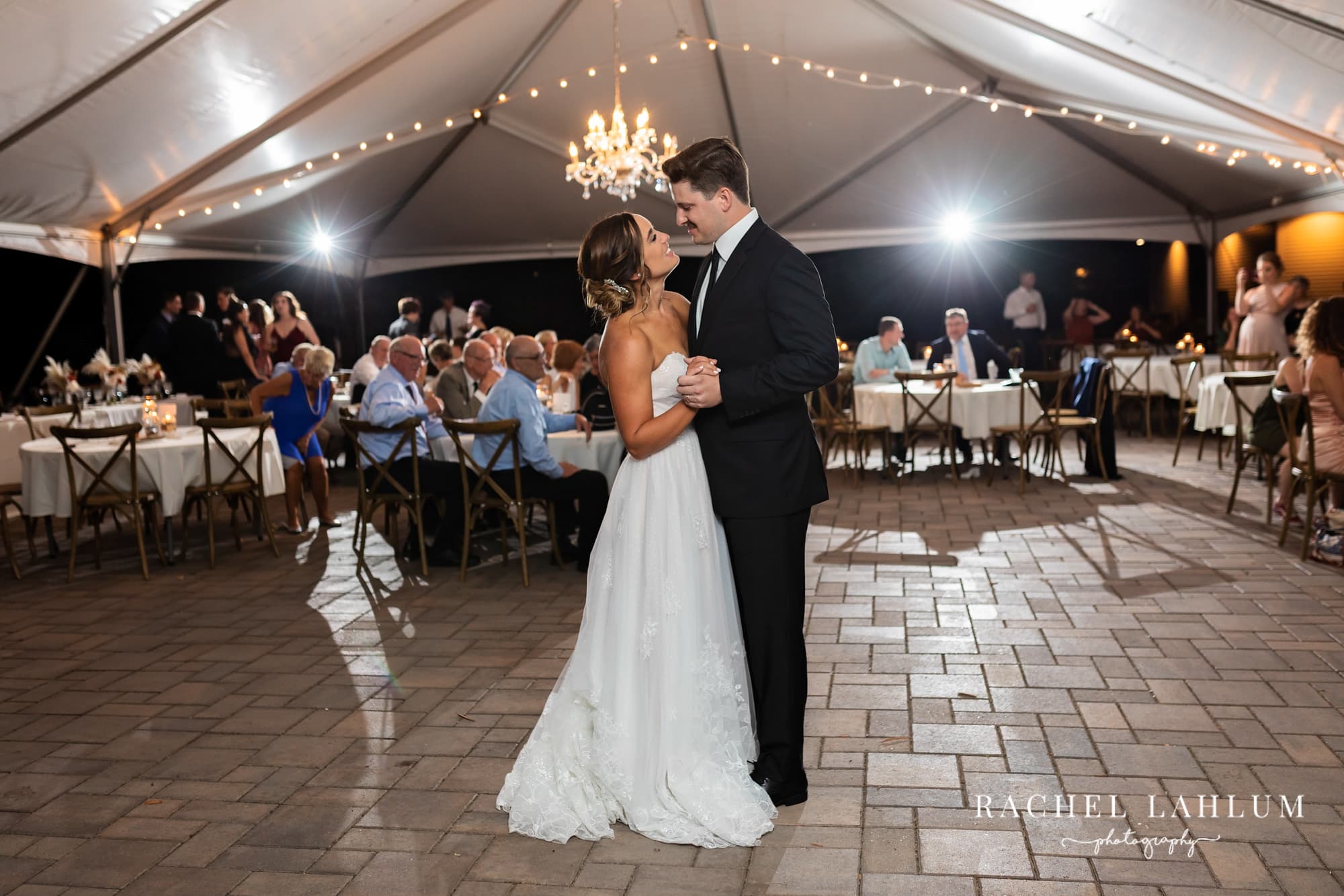 Bride and groom share a first dance at night, beneath the tent at Legacy of the Lakes Museum in Alexanrdia, Minnesota.