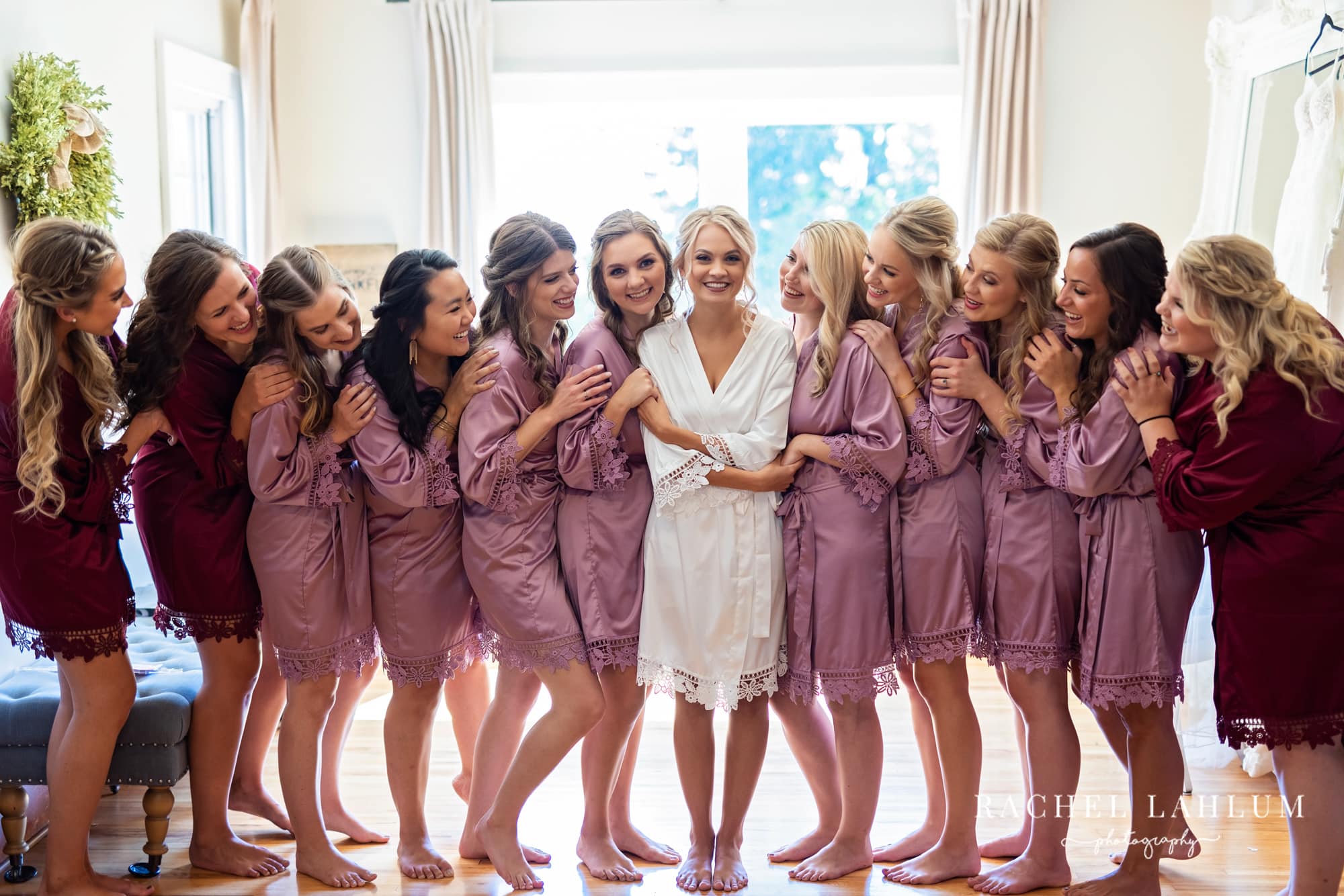 Bride stands in center surrounded by her bridesmaids at The Cottage Farmhouse in Glencoe, Minnesota.