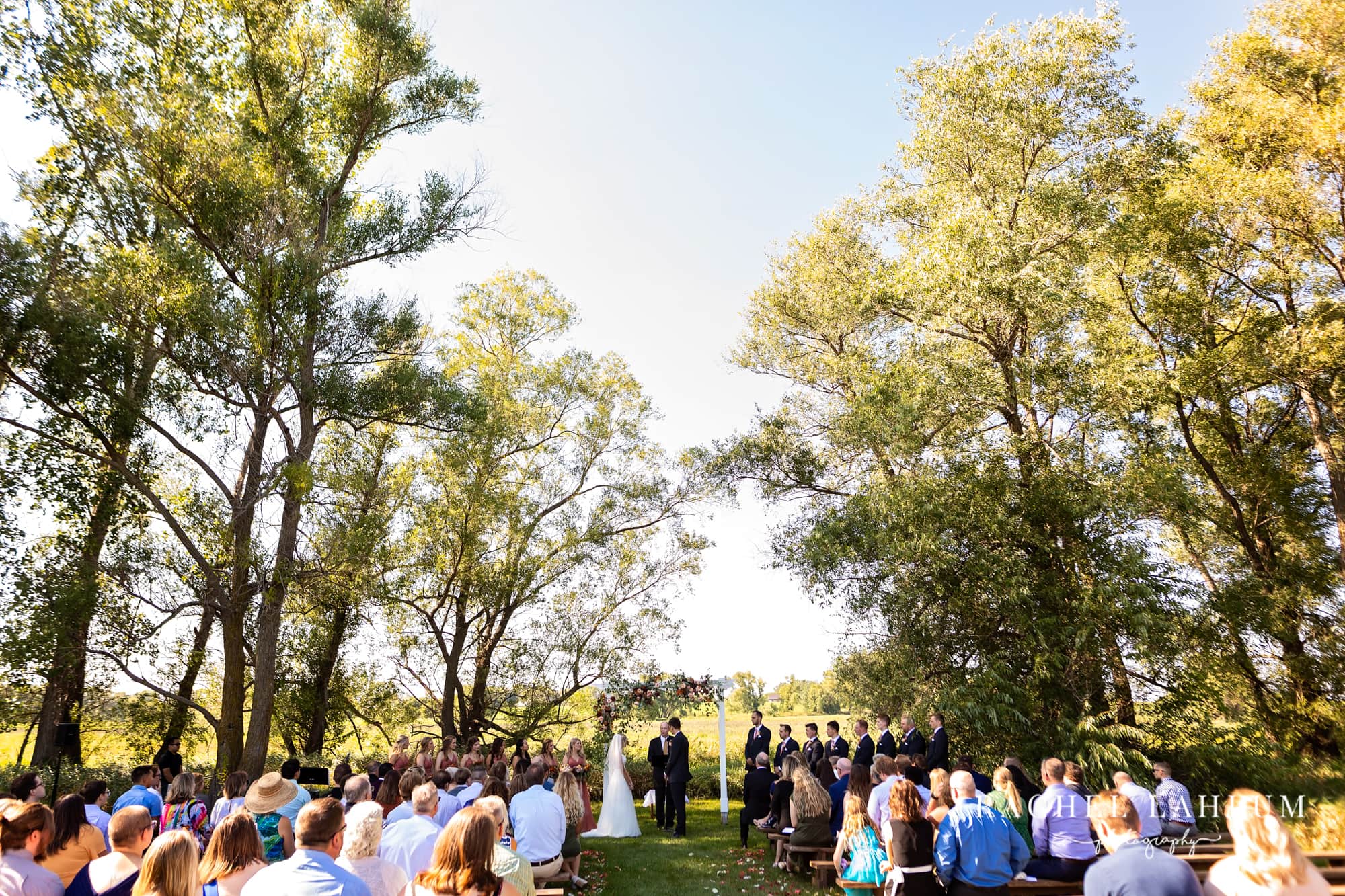 Wide shot of outdoor wedding ceremony pasture at The Cottage Farmhouse. 