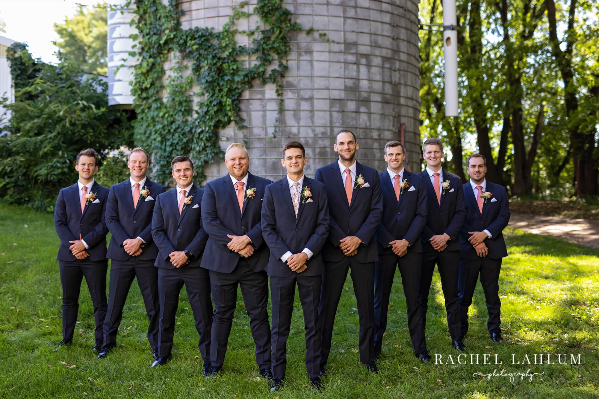 Groom and groomsmen pose in front of the silo at The Cottage Farmhouse. 