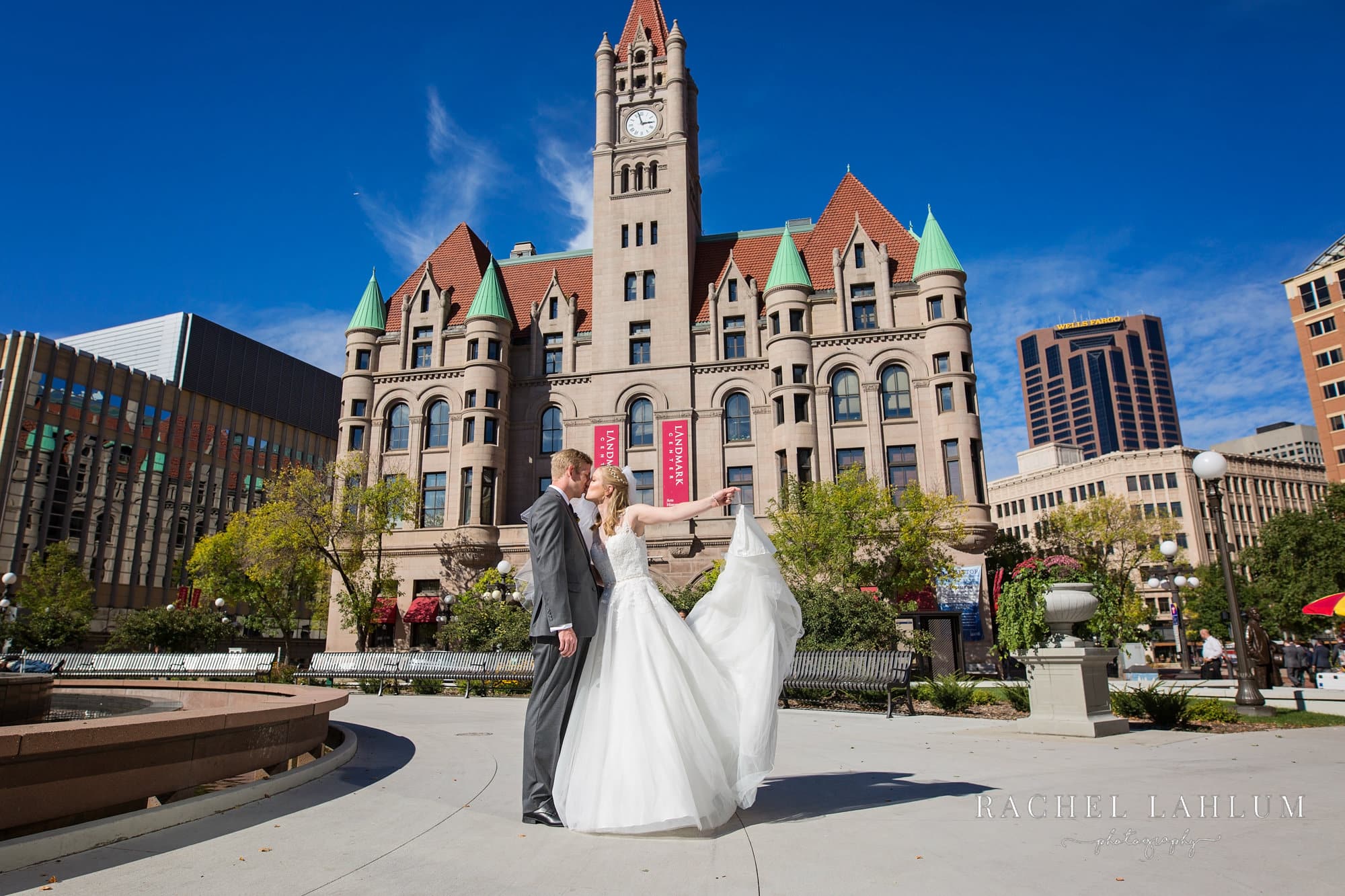 Bride and groom kiss in front of historic Landmark Center in downtown St. Paul, MN. 