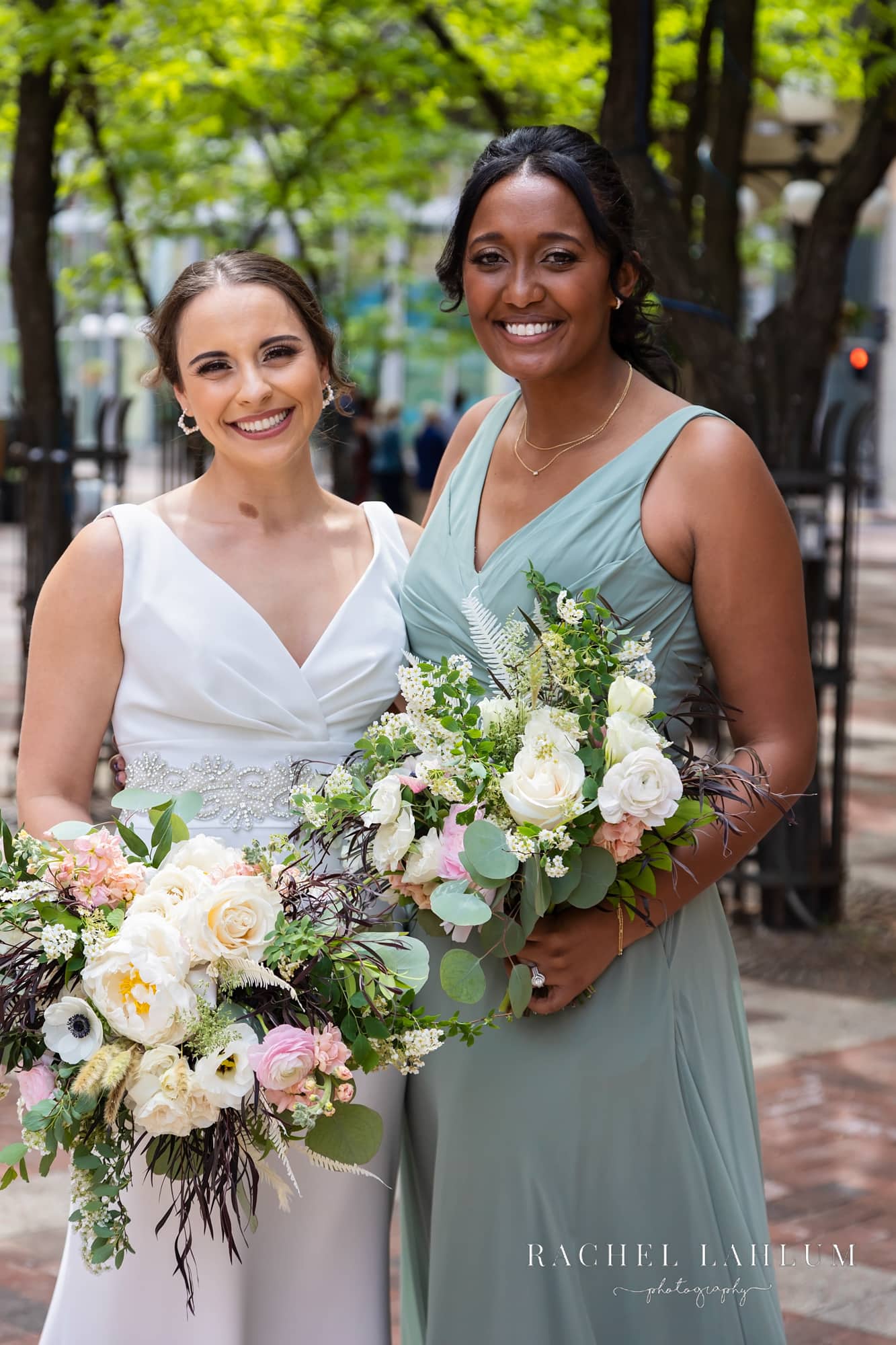 Bride and maid-of-honor pose in Saint Paul’s Seventh Place Plaza