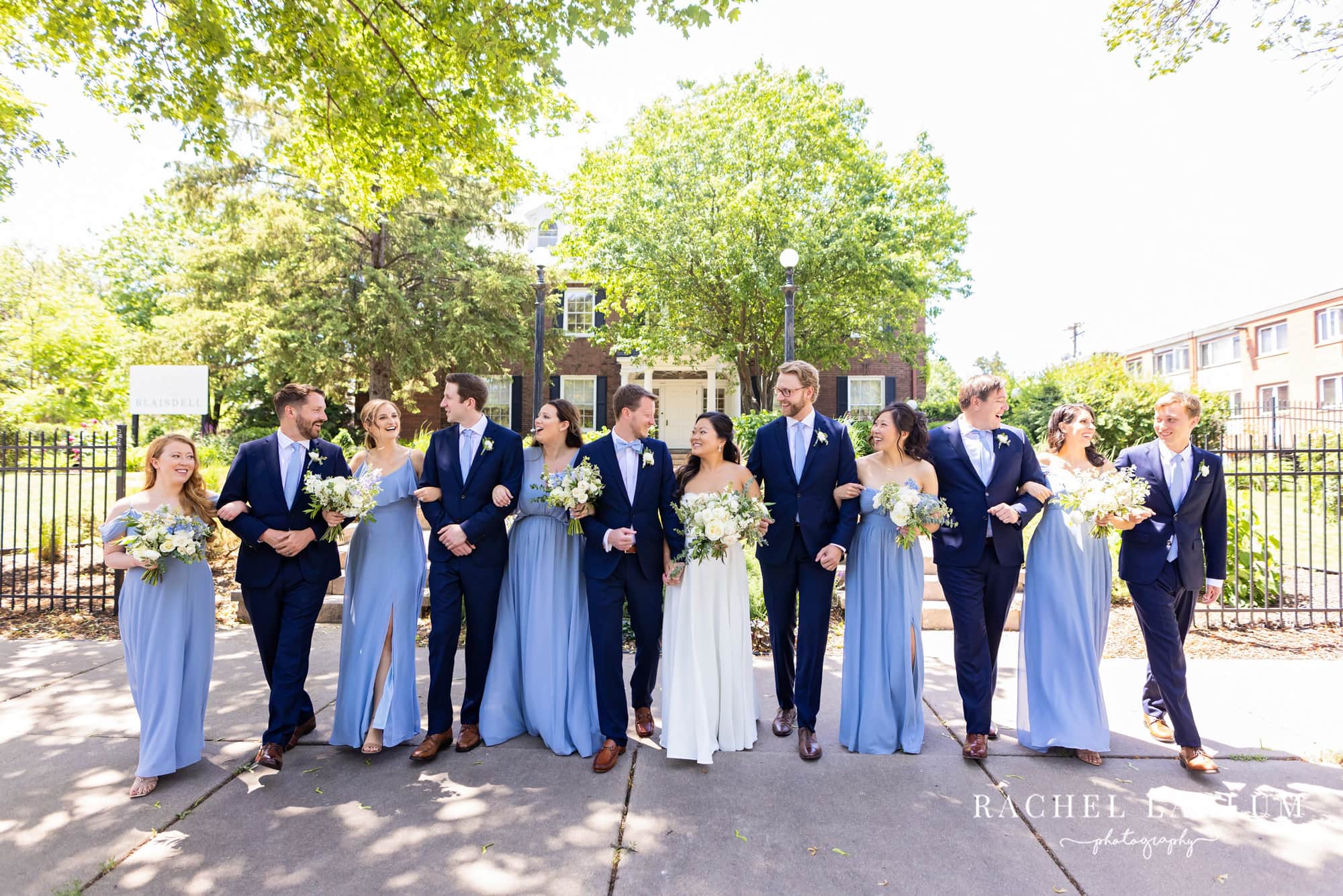 Wedding party walks arm-in-arm outside the gates of The Blaisdell in Minneapolis, Minnesota. 