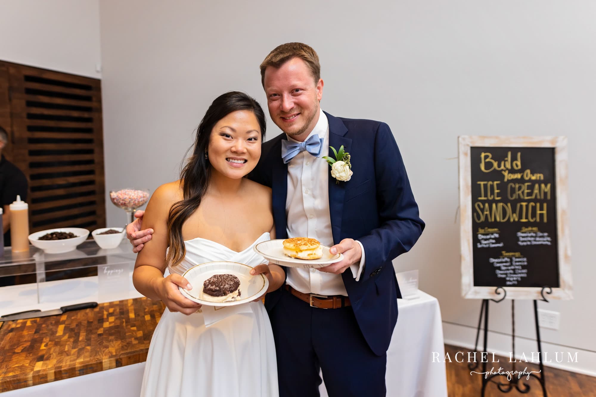 Bride and groom hold plates of desserts at the ice cream sandwich station during their reception at The Blaisdell.