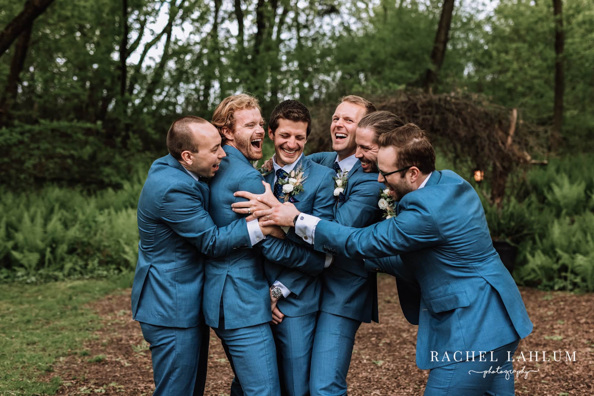 Groomsmen embrace groom in a big hug before wedding ceremony at Camrose Hill Flower Farm.