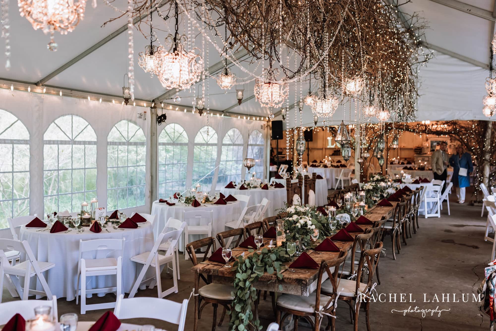 Branches and chandeliers hang over a decorated reception table at Camrose Hill Flower Farm in Stillwater, Minnesota.