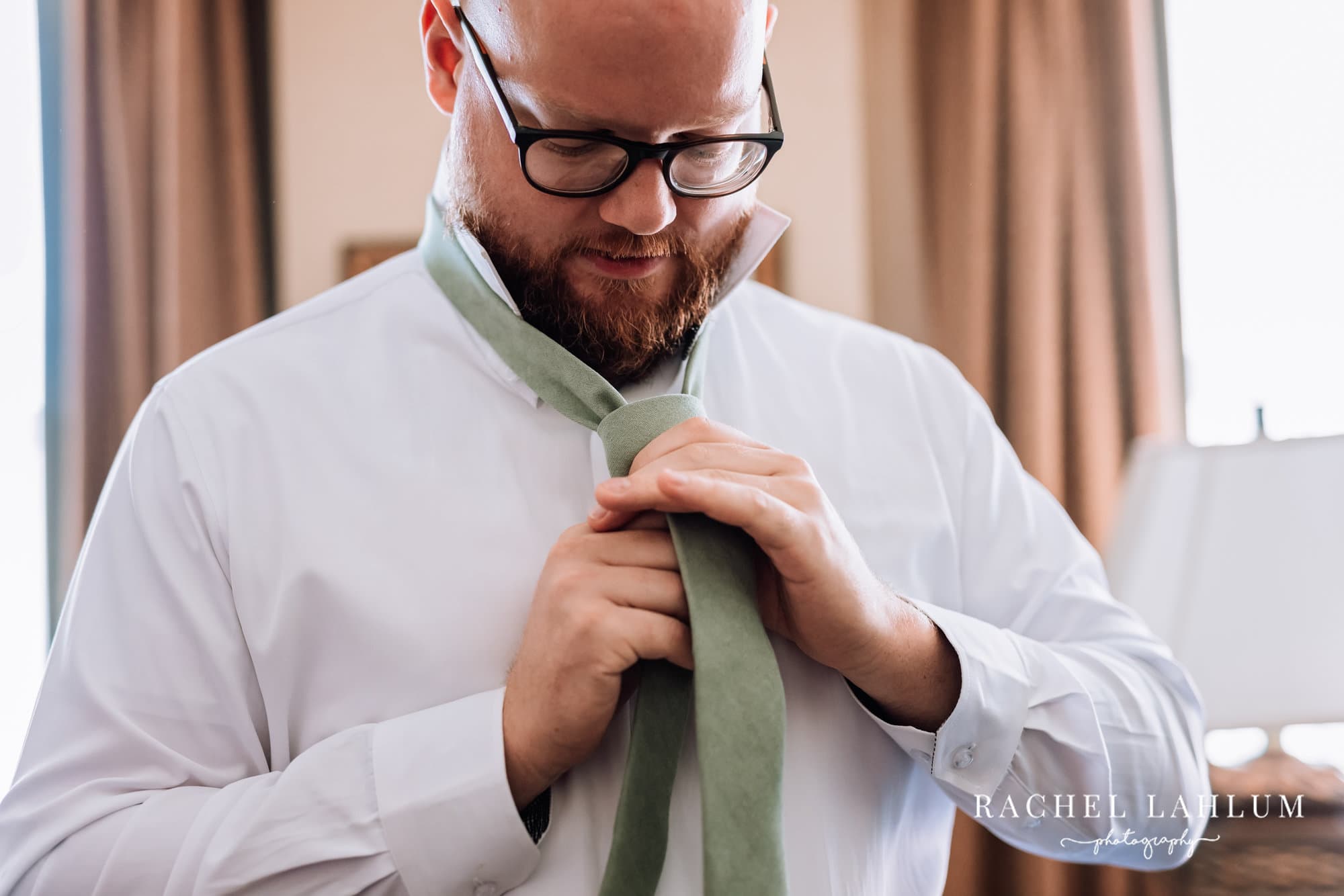Groom adjusts his tie before wedding at Harriet Island, St. Paul, MN