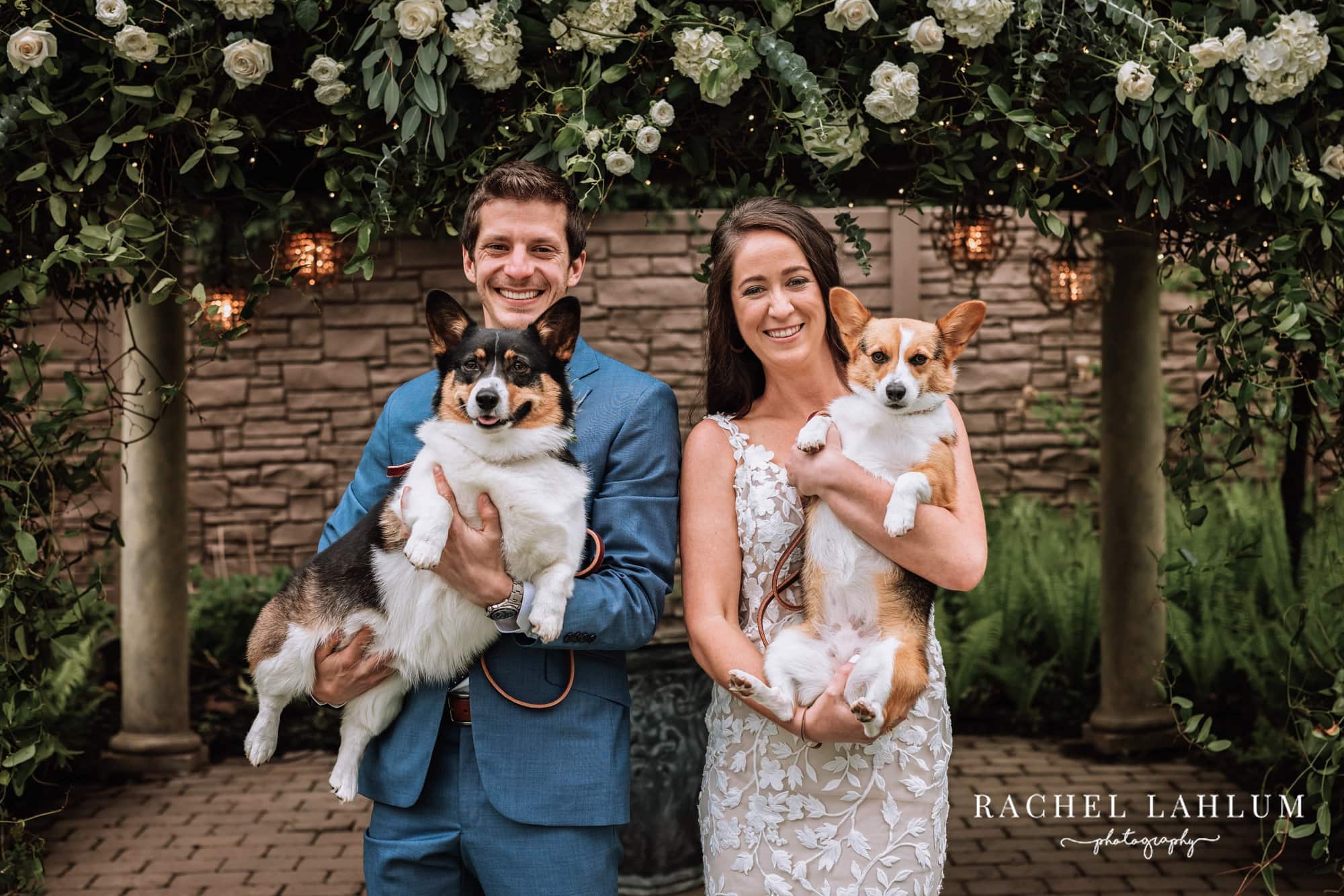 Bride and groom pose with their corgis in their arms in Stillwater, MN.