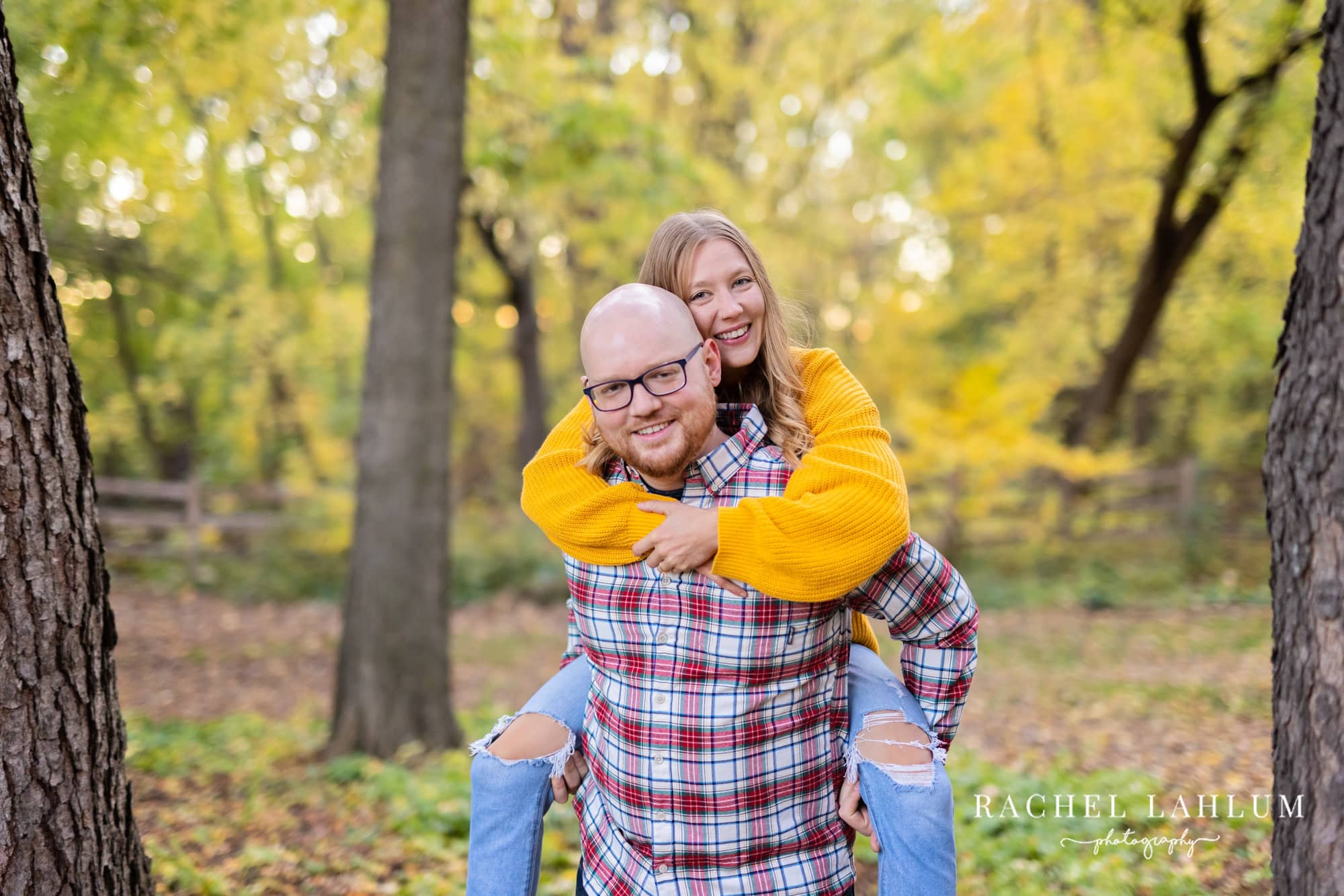 Man gives fiancée a piggy-back ride during engagement photo shoot at Lyndale Rose Gardens.