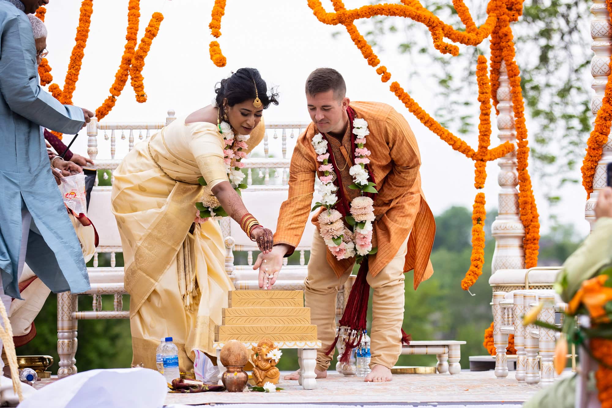 Bride and groom put puffed rice into the fire at their traditional Indian wedding ceremony at Glen Oaks Country Club.