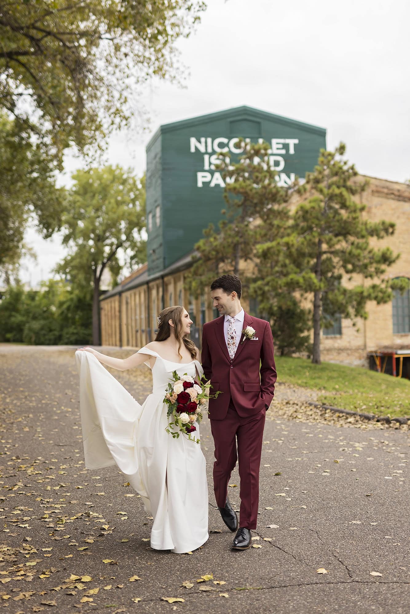 A bride and groom pose for their wedding photography outside their wedding venue, the Nicollet Island Pavilion in Minneapolis, MN.