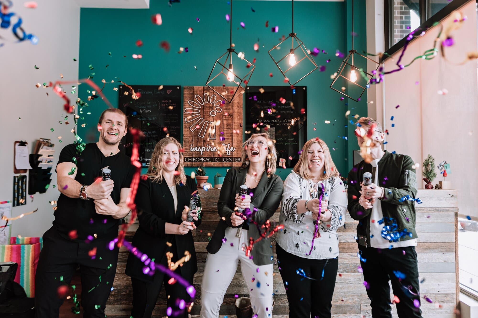 A small company shoots off confetti for a fun team photo in their office.