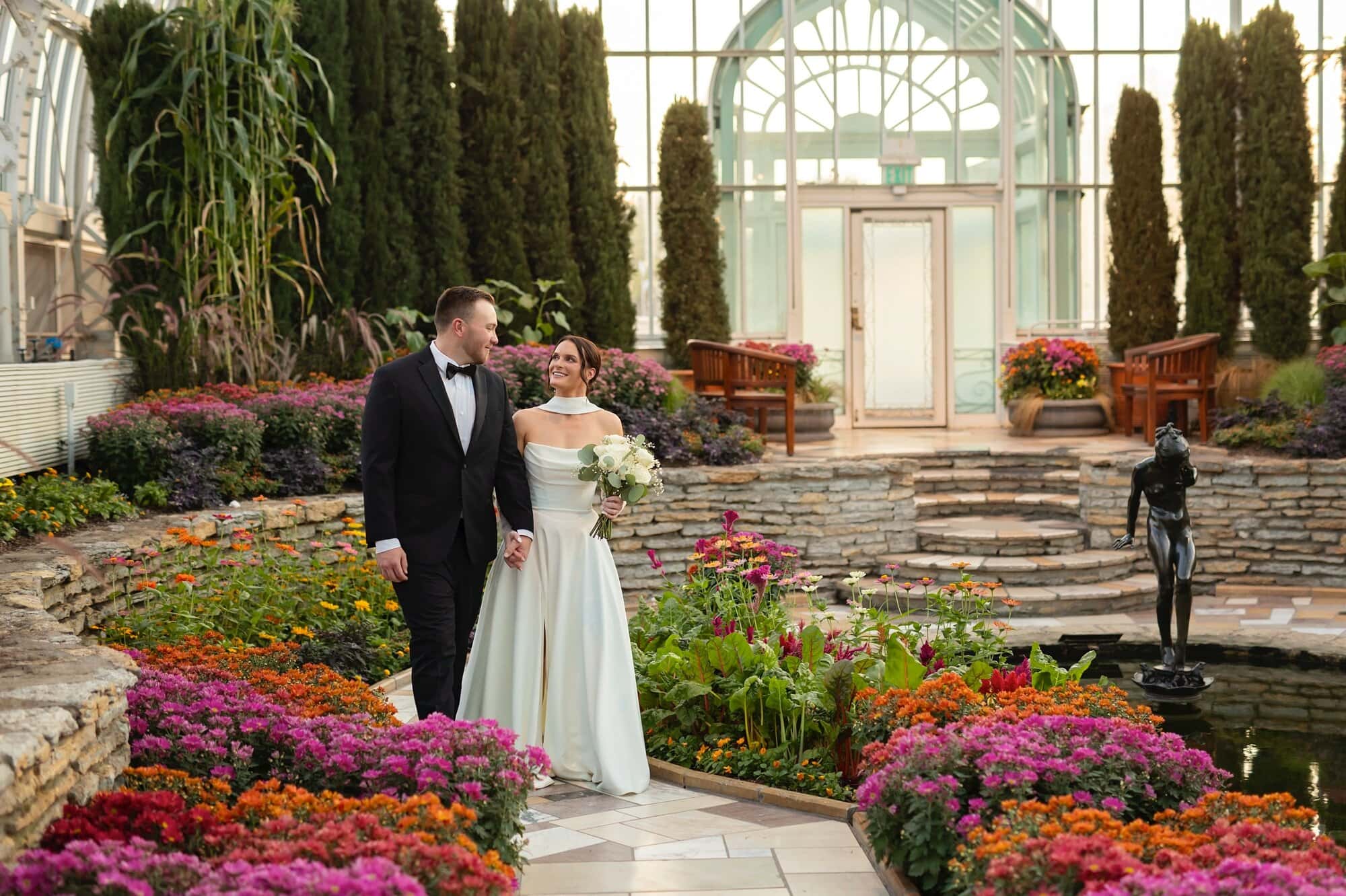 A bride and groom walk side by side for their wedding photography at Como Conservatory in St Paul, MN.