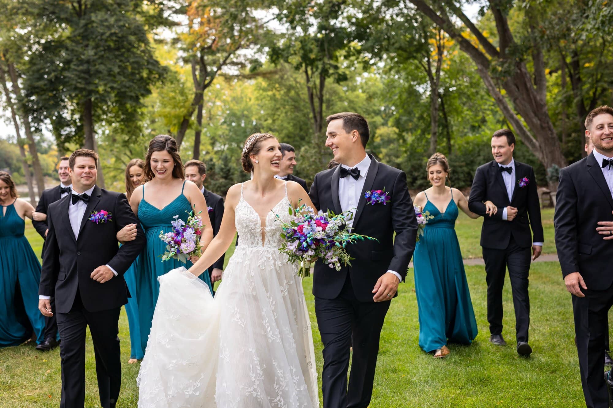 Wedding party group portait with couples linking arms and a close-up of the bride and groom walking through Leopold's Mississippi Gardens, NE Minneapolis