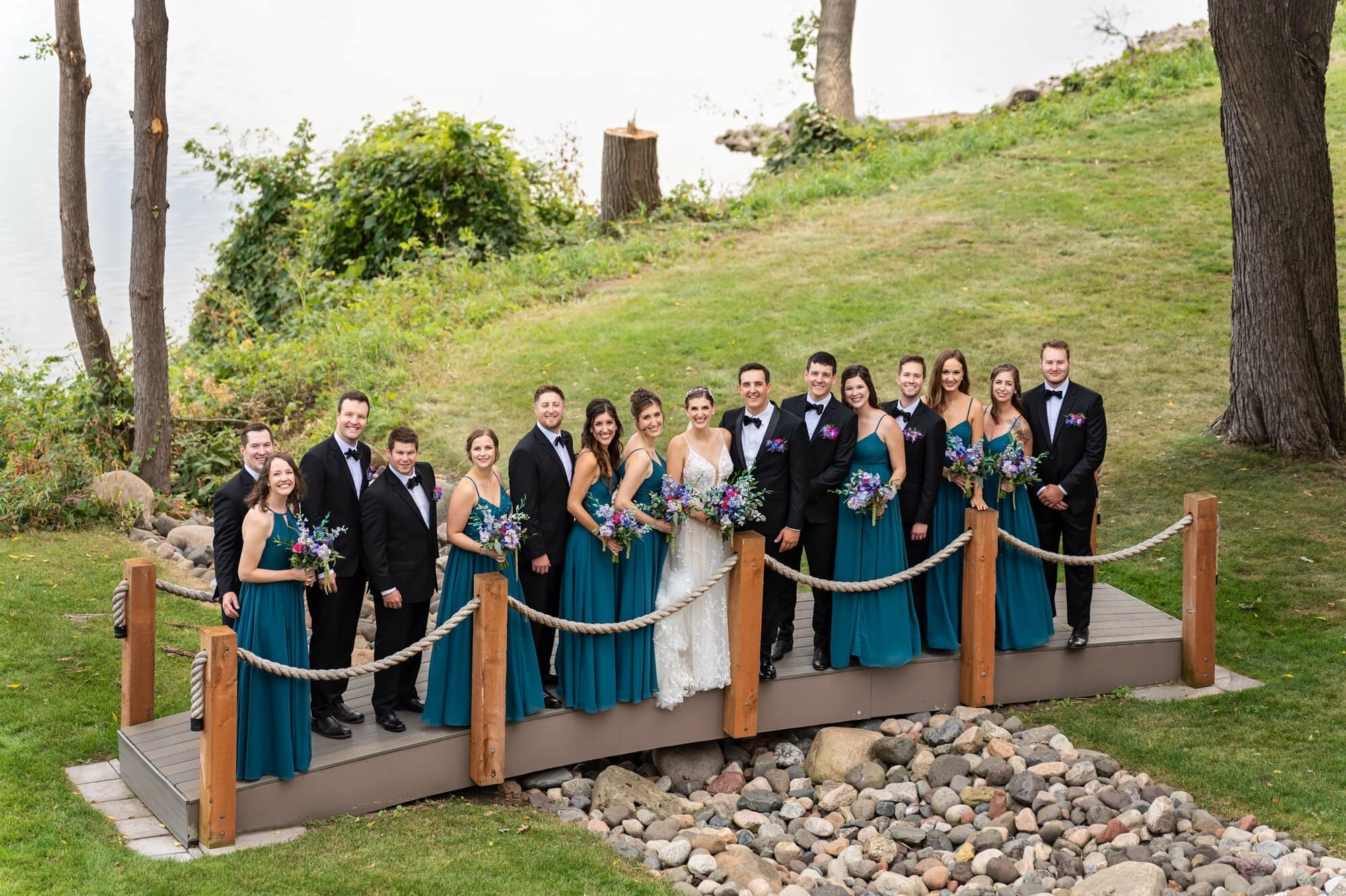Wedding party group portrait on roped-off bridge near the Missisippi Riverside in the Leopold's Mississippi Gardens, NE Minneapolis