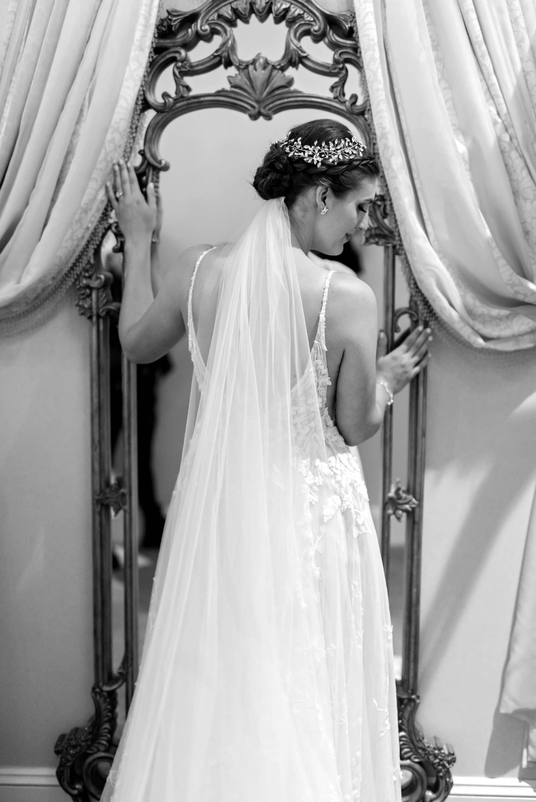 An intimate, romantic black and white bridal portait where the bride stands in front of the mirror and glances downwards for a stunning Leopold's Mississippi Gardens wedding in NE Minneapolis