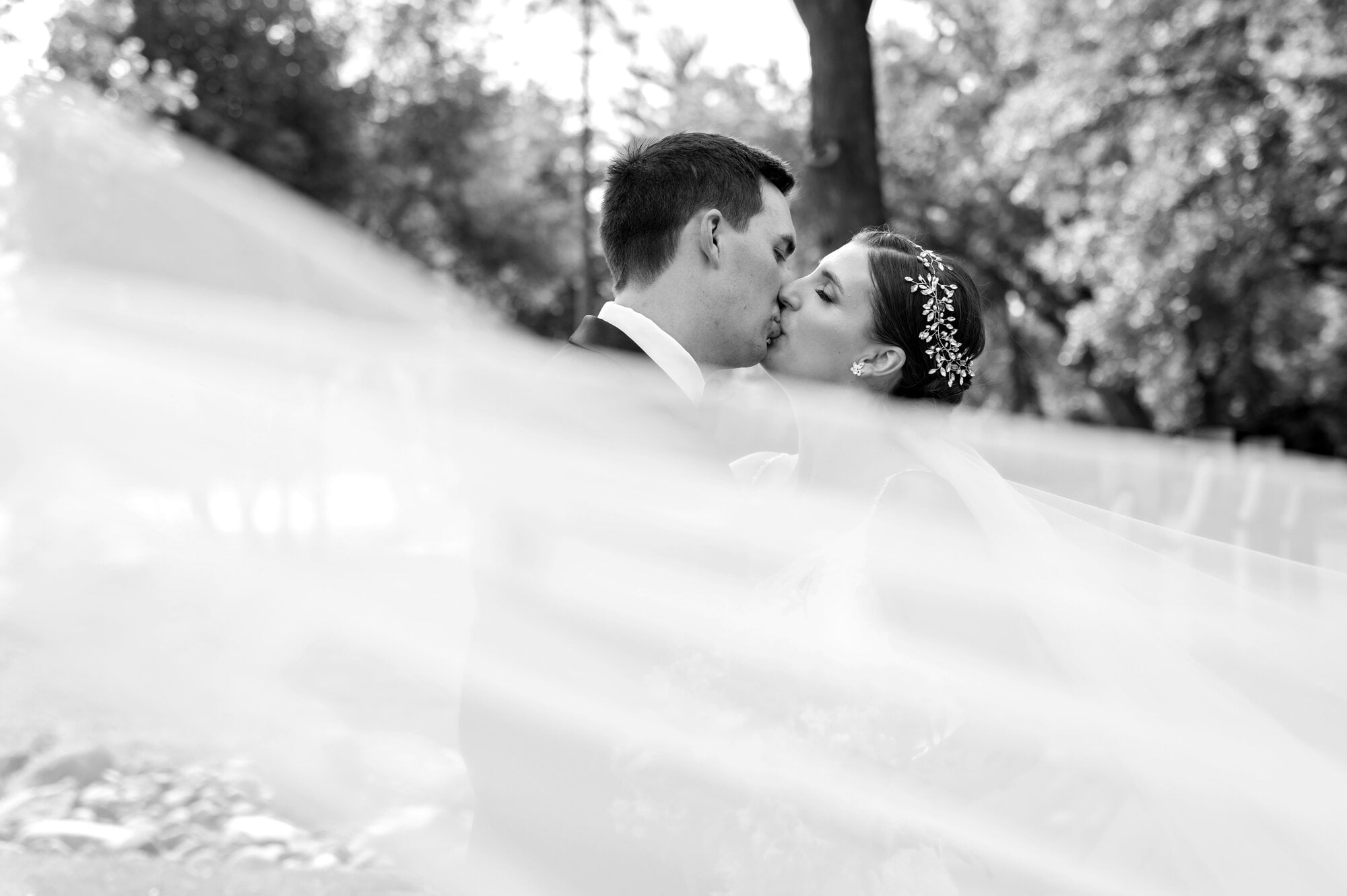 Bride and groom kissing during modern movement shot for wedding photography in Leopold's Mississippi Gardens, NE Minneapolis