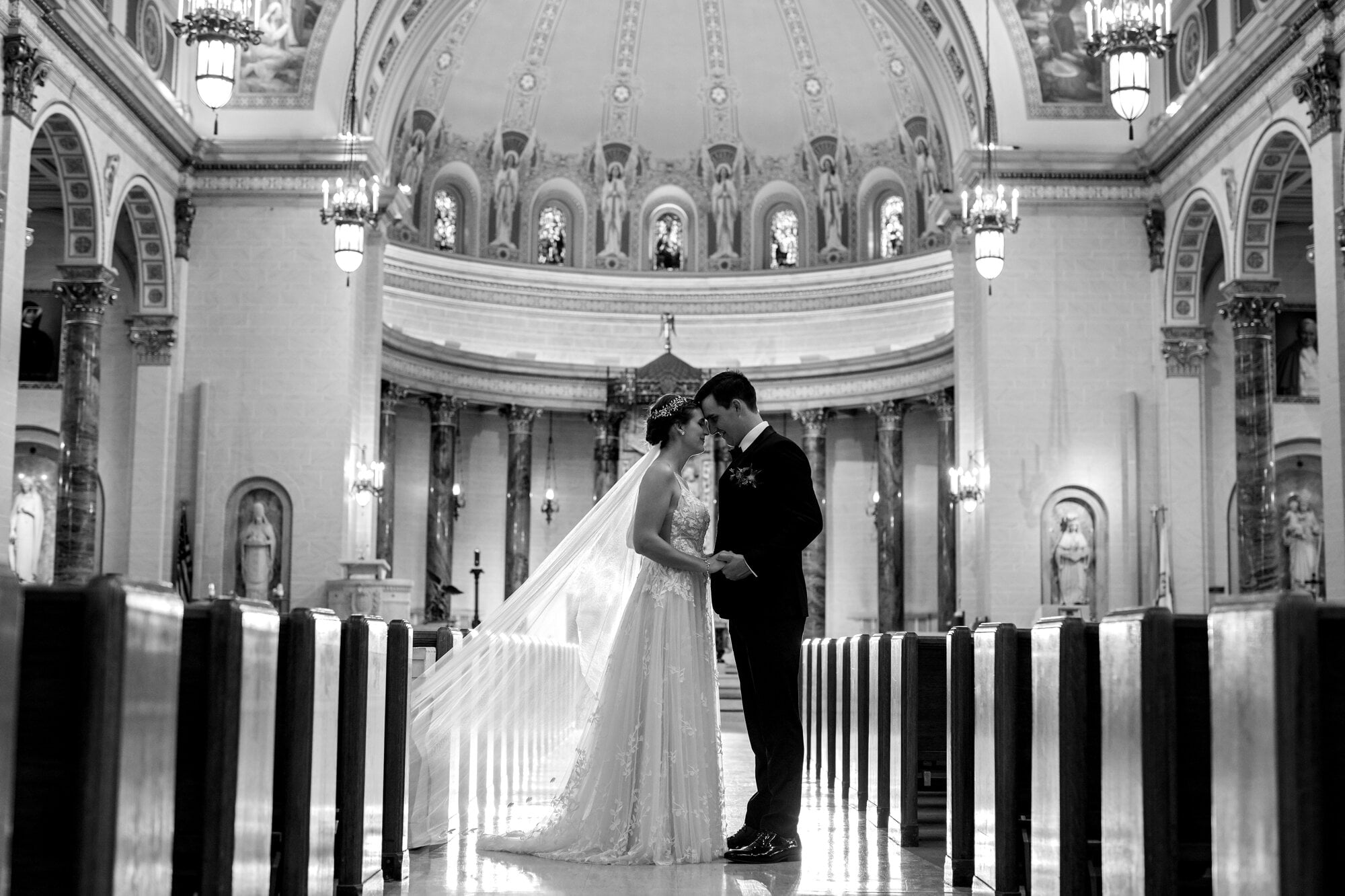 Stunning view of bride and groom standing head-to-head for a black and white pre-ceremony portait inside the Holy Cross Catholic Church, NE Minneapolis