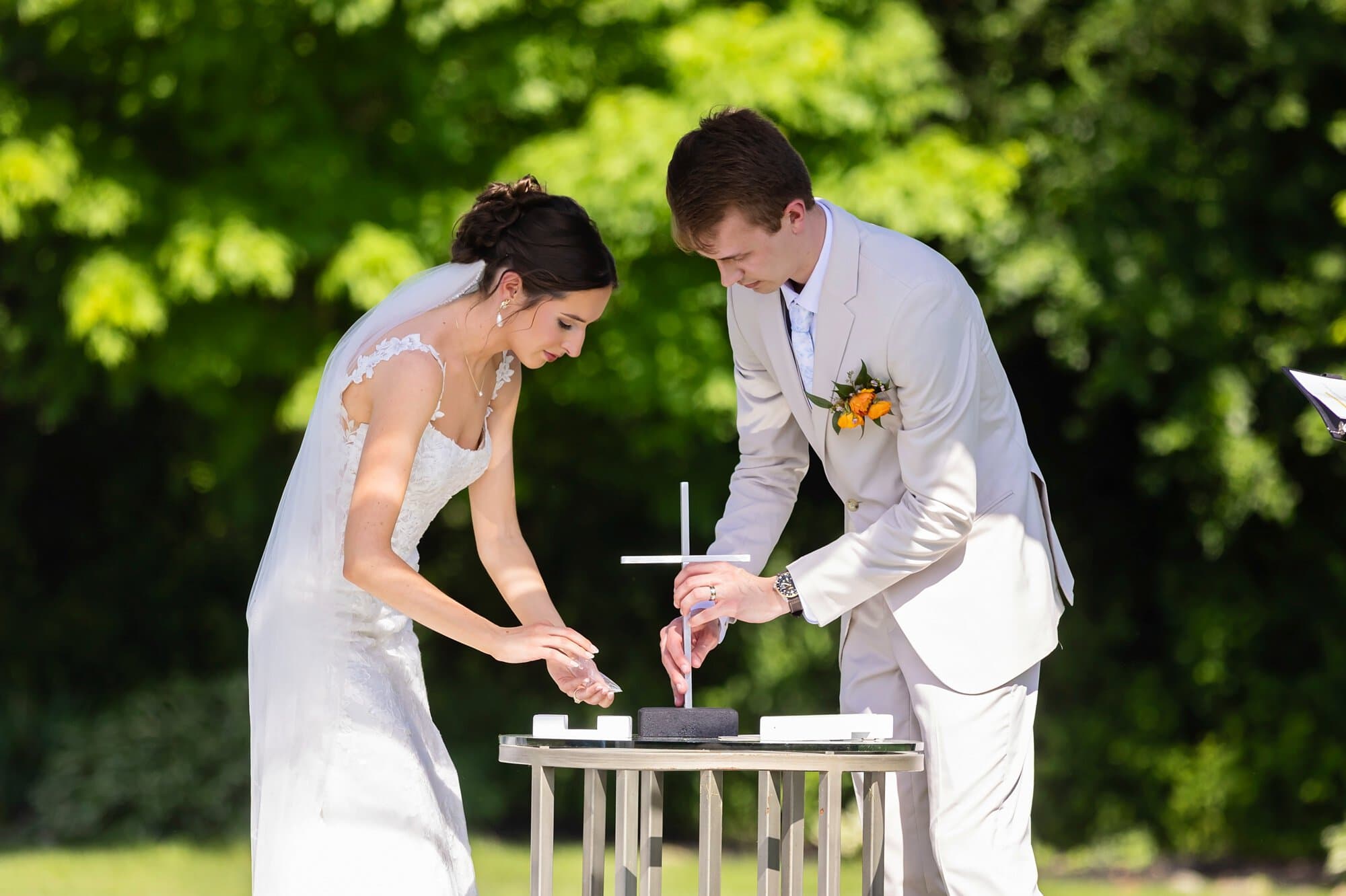 Bride and groom assemble a unity cross together as part of the ceremony.
