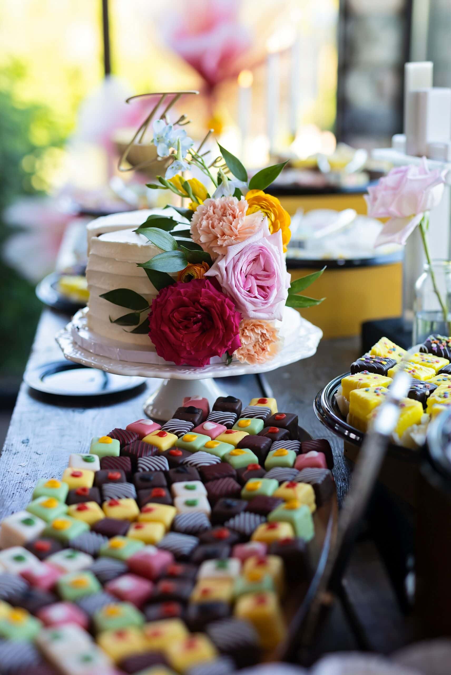 Vibrantly colored cake and mini desserts with flowers at the reception at Ridgetop Events.