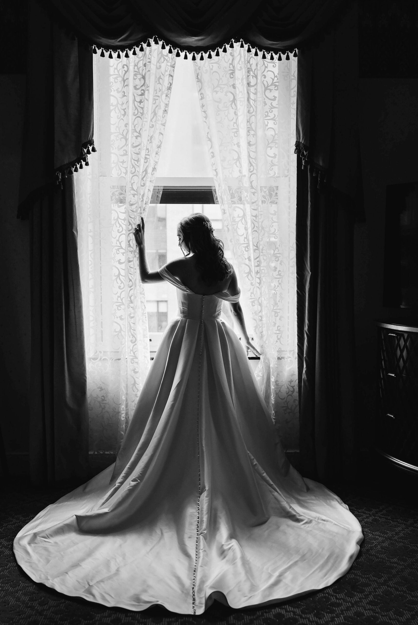 Bride stands in front of a window for a luxury wedding photograph at the Renaissance Depot Hotel in Minneapolis, MN.