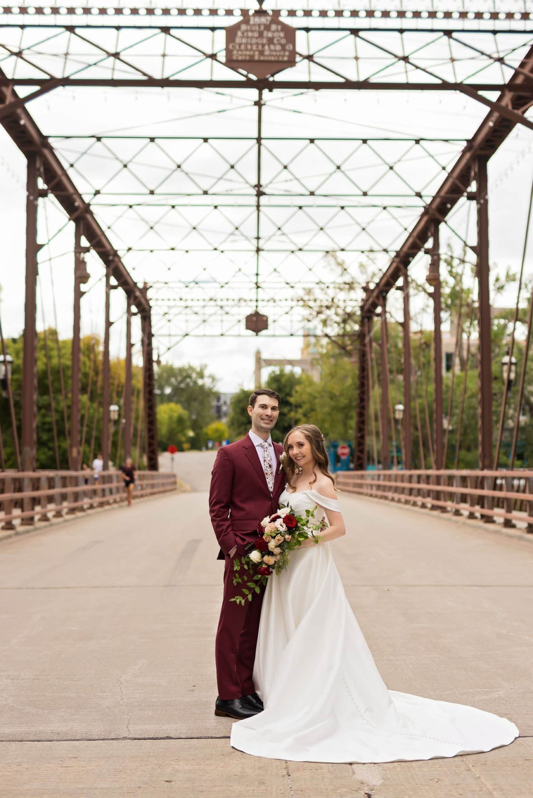 Bride and Groom pose together for a wedding portrait on the Nicollet Island Bridge in Minneapolis, MN.