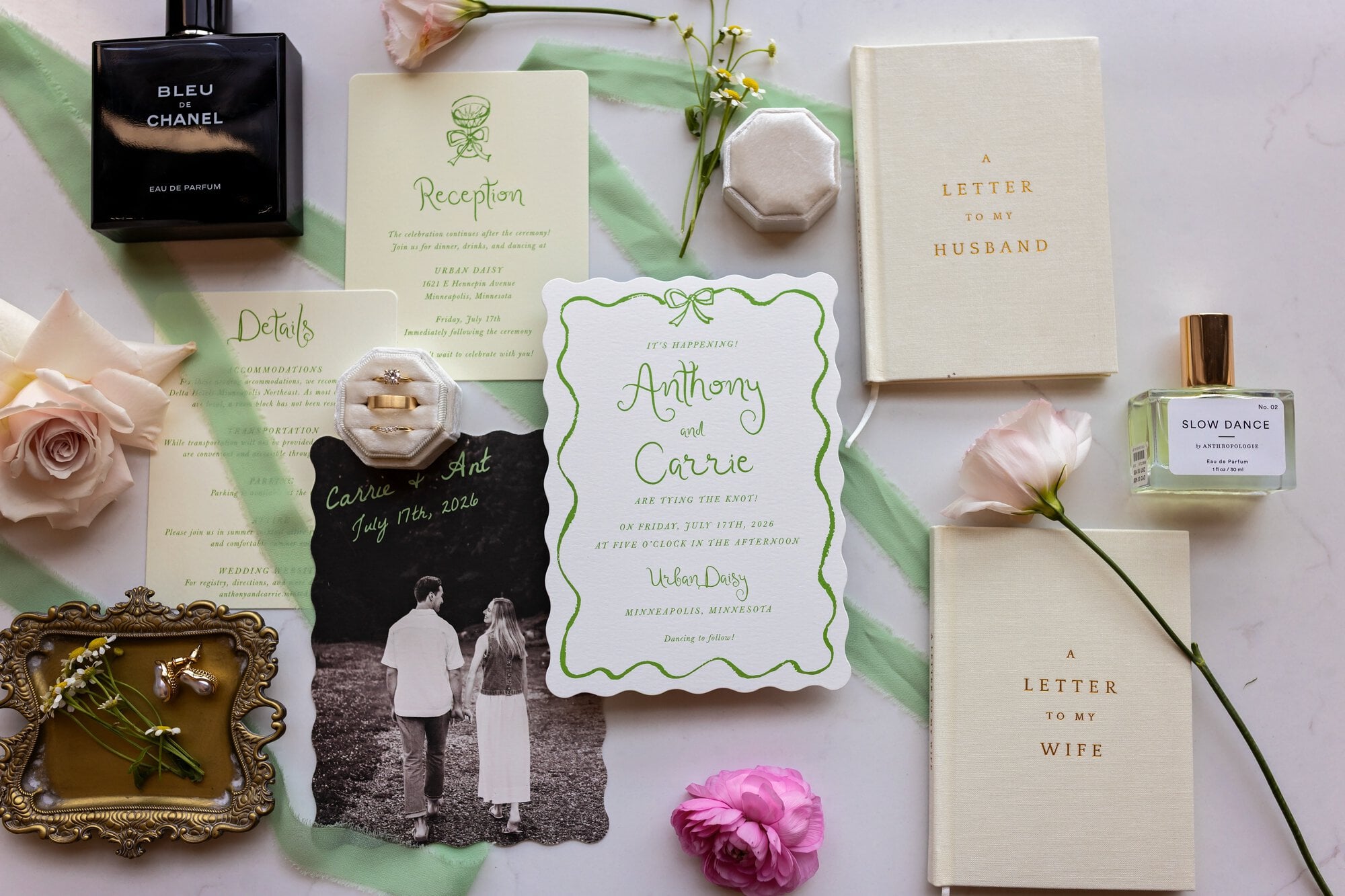 A collection of wedding day memorabilia including the rings, perfume, flowers, and designed stationery in Minneapolis, Minnesota