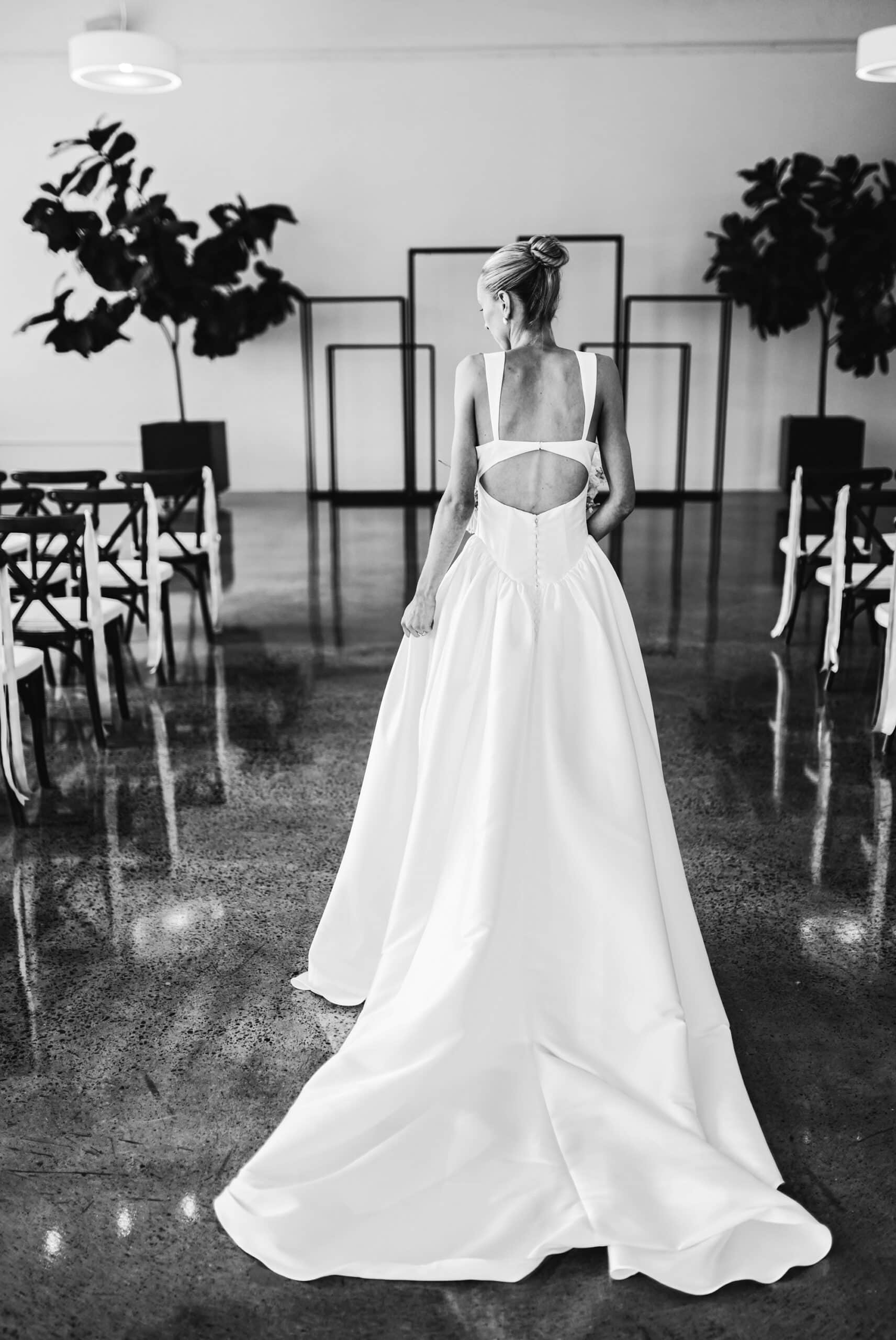 Bride walks down the decorated aisle in a black and white portait at the Urban Daisy in Minneapolis, Minnesota
