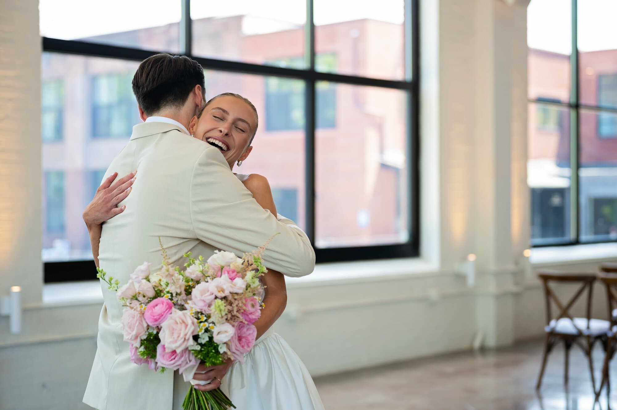 Bride and groom embrace during first-look photos at the Urban Daisy in Minneapolis, Minnesota